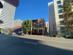 Los Angeles apartment for rent - A city street with cars and buildings on either side.