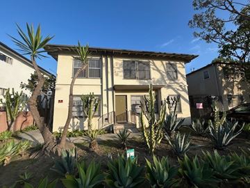 Los Angeles apartment for rent - A house with a yellow door and a green sign in front of it.