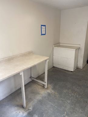 Los Angeles apartment for rent - A white desk and a white dresser are in a room with a blue paper on the wall.