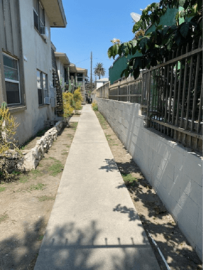 Los Angeles apartment for rent - A concrete pathway leads down a street between two houses.