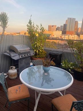 Los Angeles apartment for rent - A table with a vase on it and a chair with a paint splatter on it.