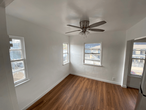 Los Angeles apartment for rent - A room with a ceiling fan and wooden floors.