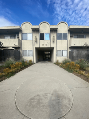 Los Angeles apartment for rent - A concrete walkway leads to a building with a circular design on the ground.
