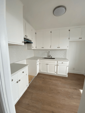 Los Angeles apartment for rent - A kitchen with white cabinets and a white backsplash.