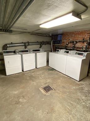 Los Angeles apartment for rent - A row of white washing machines in a basement.