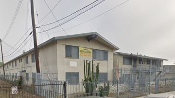 Compton apartment for rent - A building with a sign that says "Now Lease" in front of it.
