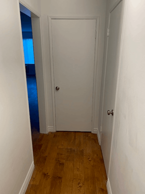 Los Angeles apartment for rent - A white door is in a hallway with wood floors.