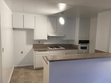 Los Angeles apartment for rent - A kitchen with white cabinets and a granite countertop.
