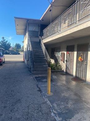 Los Angeles apartment for rent - A concrete staircase with a yellow post in front of a building.