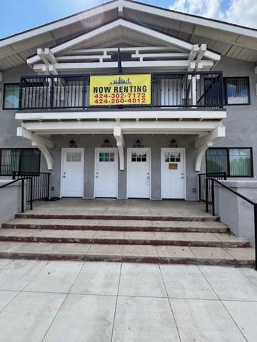 Los Angeles apartment for rent - A two-story building with a balcony and a sign that says "NOW RENTING" is for sale.
