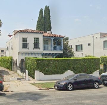 Los Angeles apartment for rent - A black car is parked in front of a white house with a red tile roof.