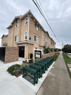 San Gabriel apartment for rent - A row of green chairs are lined up on a sidewalk in front of a building.