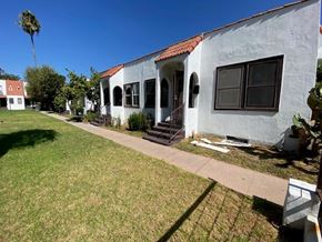 Los Angeles apartment for rent - A white house with a red tile roof and a palm tree in the background.