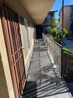 Los Angeles apartment for rent - A long, narrow walkway with a metal railing on the right side.
