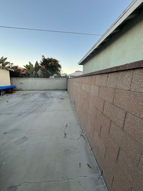 Inglewood apartment for rent - A backyard with a concrete floor and a brick wall.