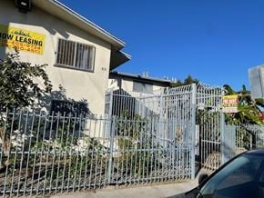 Compton apartment for rent - A car is parked in front of a fence with a sign that says "Now Leasing".