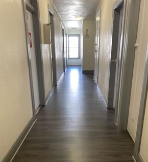 Bell apartment for rent - A long hallway with doors on both sides and a light at the end.