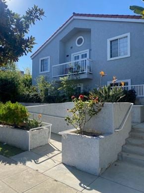 Santa Monica apartment for rent - A grey house with a balcony and a small garden in front.