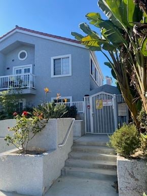 Santa Monica apartment for rent - A grey house with a red roof and a white fence.