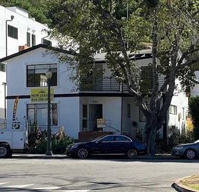 Los Angeles apartment for rent - A two-story white house with a black car parked in front.