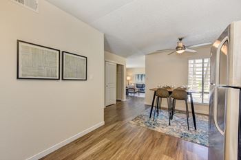 Model home looking from kitchen towards the dining area and living room.  Showcasing the hardwood flooring.