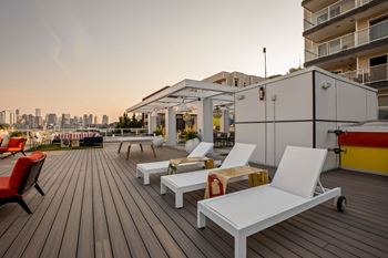 A wooden deck with white chairs 