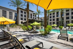 Phoenix apartment for rent - A pool area with sun loungers and umbrellas.