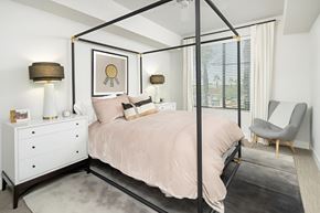 Phoenix apartment for rent - A bedroom with a four poster bed, a chair, and a dresser.