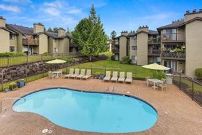 Kent apartment for rent - A swimming pool surrounded by a fence and chairs in a residential area.