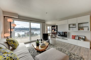 Seattle apartment for rent - a living room with a large window and a couch and a table