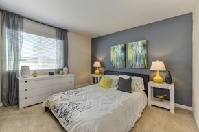 Sacramento apartment for rent - Bedroom with Large Window, White Comforter on Mattress, Lamps and Carpet at Monte Bello Apartments, Sacramento