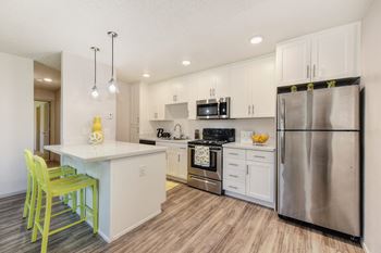 2 Bedroom, one bath floor plan kitchen showing white cabinets, quartz counters and stainless appliances.