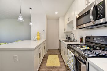 2X1 floor plan kitchen area with electric stove, oven, microwave and dishwasher.