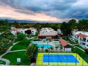 Lancaster apartment for rent - A tennis court is surrounded by a pool and apartment buildings.