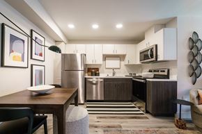 Sacramento apartment for rent - a kitchen with stainless steel appliances and a wooden table at Track 281 Apartments, Sacramento, 95811