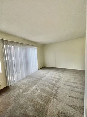 Canoga Park apartment for rent - A room with a carpeted floor and a window with blinds.