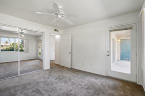 Palm Desert apartment for rent - an empty living room with white walls and a ceiling fan