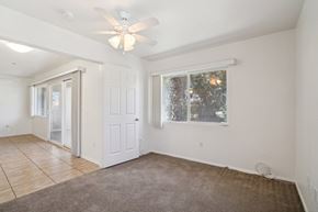 Palm Desert apartment for rent - an empty living room with a ceiling fan and a window