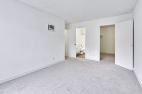 San Diego apartment for rent - A white room with a carpeted floor and a doorway leading to another room.