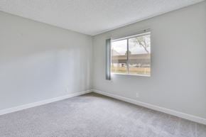 San Diego apartment for rent - A room with a carpeted floor and a window showing a parking lot outside.