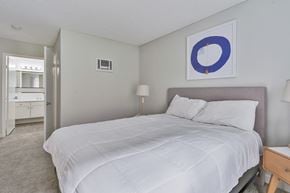 San Diego apartment for rent - A bedroom with a large bed and a painting on the wall.