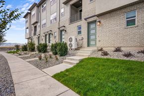 Lehi townhouse for rent - a sidewalk in front of an apartment building with grass and plants
