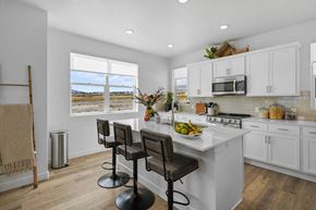 Lehi townhouse for rent - a white kitchen with a large counter and chairs