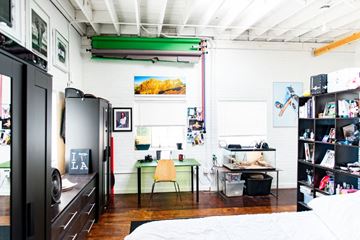 Salt Lake City apartment for rent - a bedroom with a bed and a desk and a refrigerator