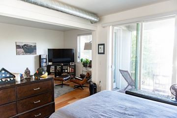 Salt Lake City apartment for rent - a bedroom with a bed and a tv and a living room with a window