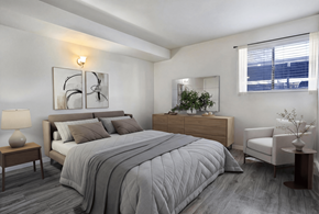 West Valley City apartment for rent - A bedroom with a large bed, a nightstand, and a chair.