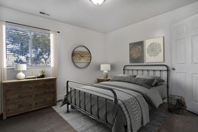 Ogden apartment for rent - A bedroom with a bed, nightstand, and window.