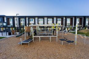 Clearfield townhouse for rent - A playground with a slide, swings, and a bench in front of a building.