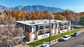 Sandy apartment for rent - A modern building with a parking lot in front of it.