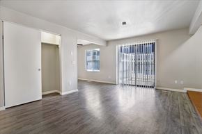 West Valley City apartment for rent - A spacious room with a sliding glass door and hardwood flooring.
